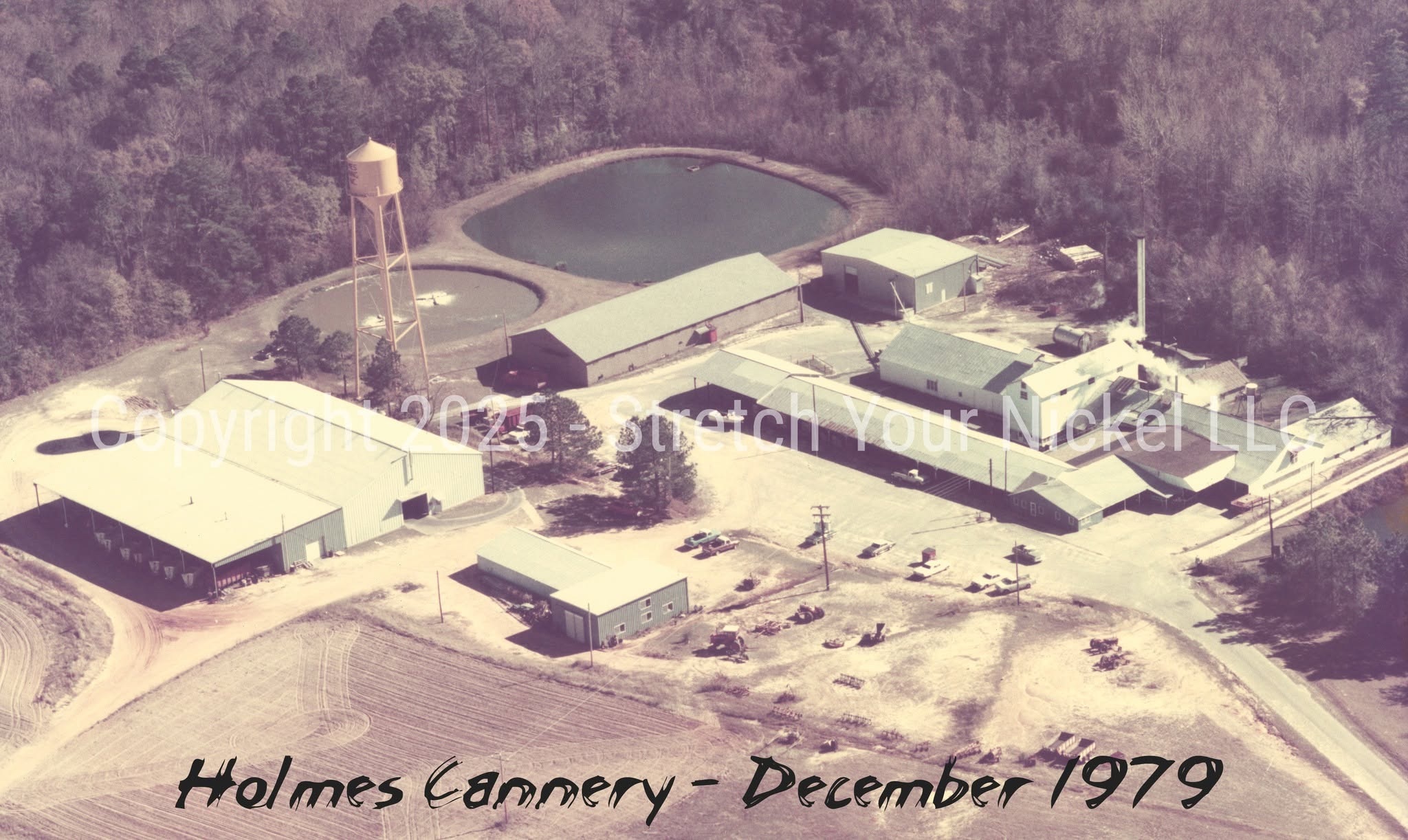 Aerial archival view of Holmes Cannery, dated December 1979, showing its buildings, water tower, and surrounding fields